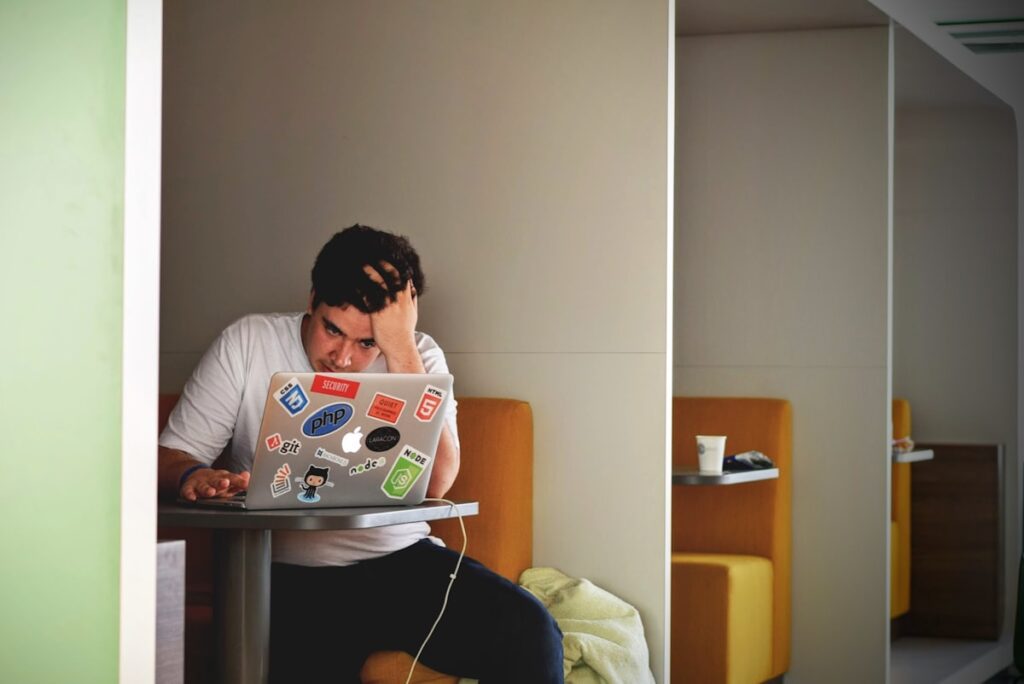 Man struggling to focus on his laptop, representing brain fog