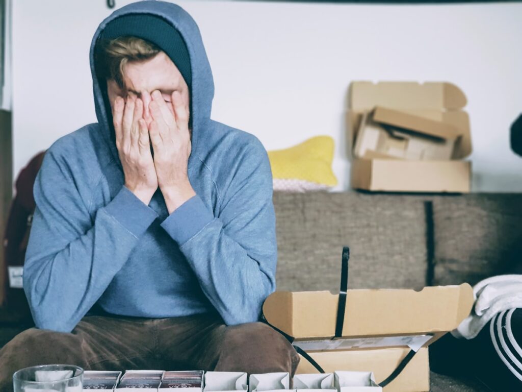 Exhausted man covering his face, showing signs of chronic fatigue
